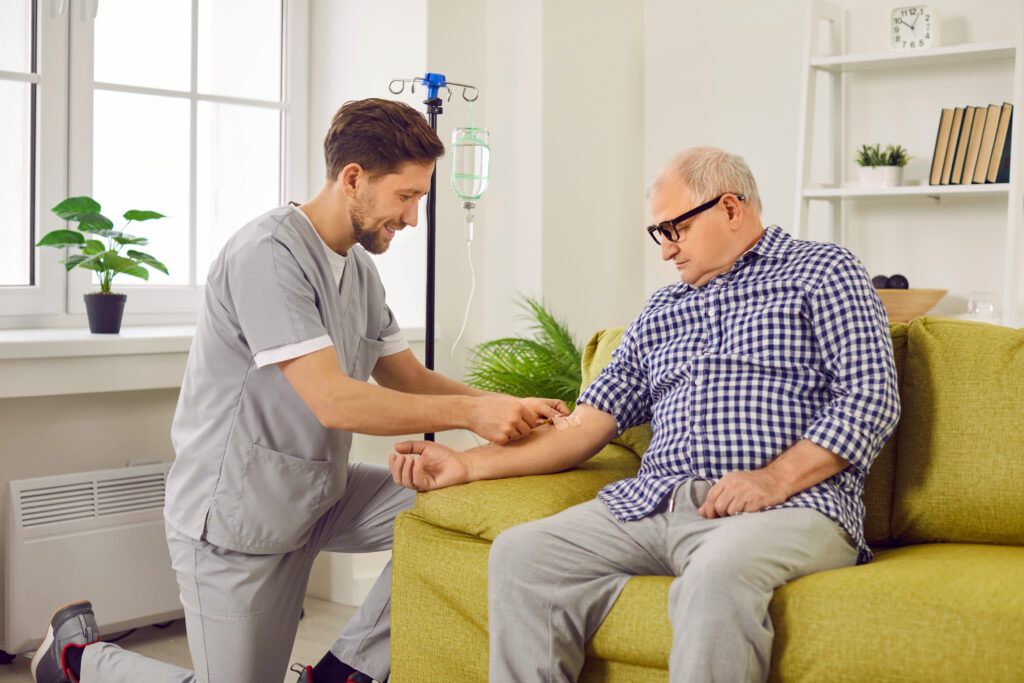 nurse or doctor gives intravenous medication or vitamin infusion to senior patient